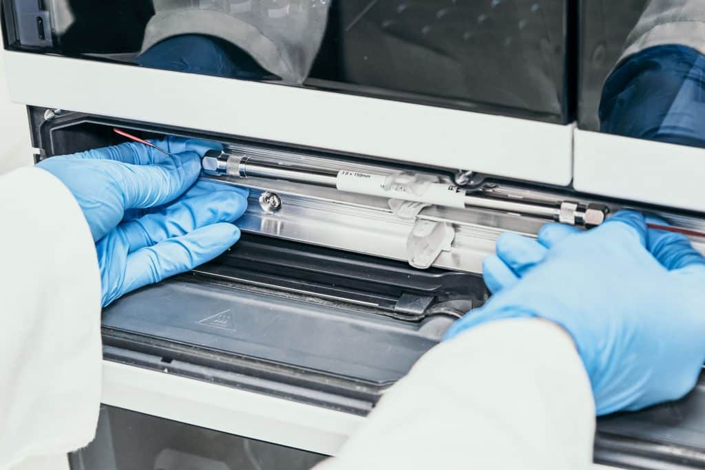 Chemist installing a column on a High Performance Liquid Chromatography Instrument (HPLC)
